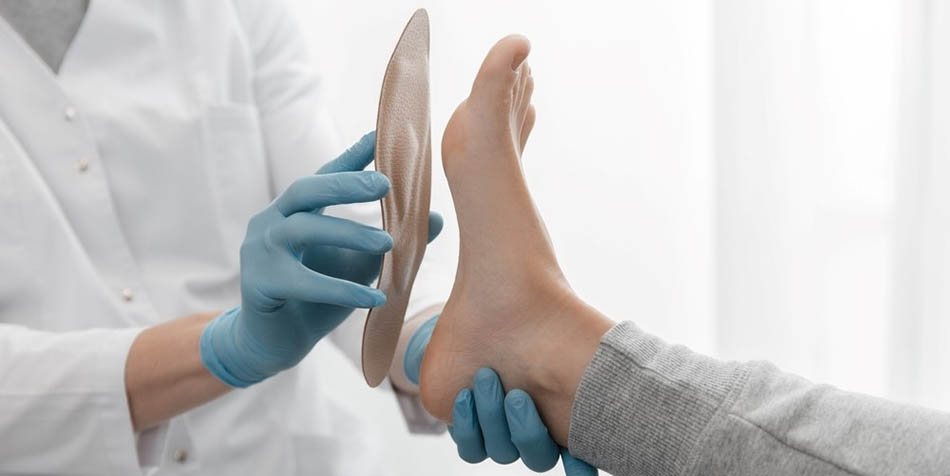 A doctor holds an orthopedic insole.