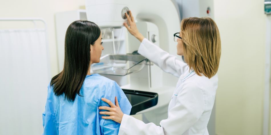 Physician and patient standing in front of medical device